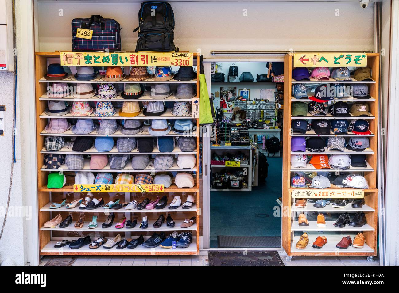 Negozio di cappelli a Shinsekai. Intera facciata del negozio, oltre alla porta, con espositori in legno con file di cappelli, cappelli da baseball e scarpe. Foto Stock