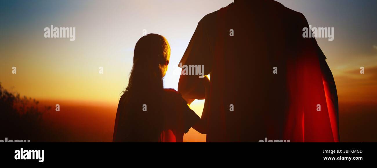 Famiglia felice amorevole. Padre e sua figlia giocano all'aperto. Daddy e la sua bambina in costumi di un Supereroe. Foto Stock