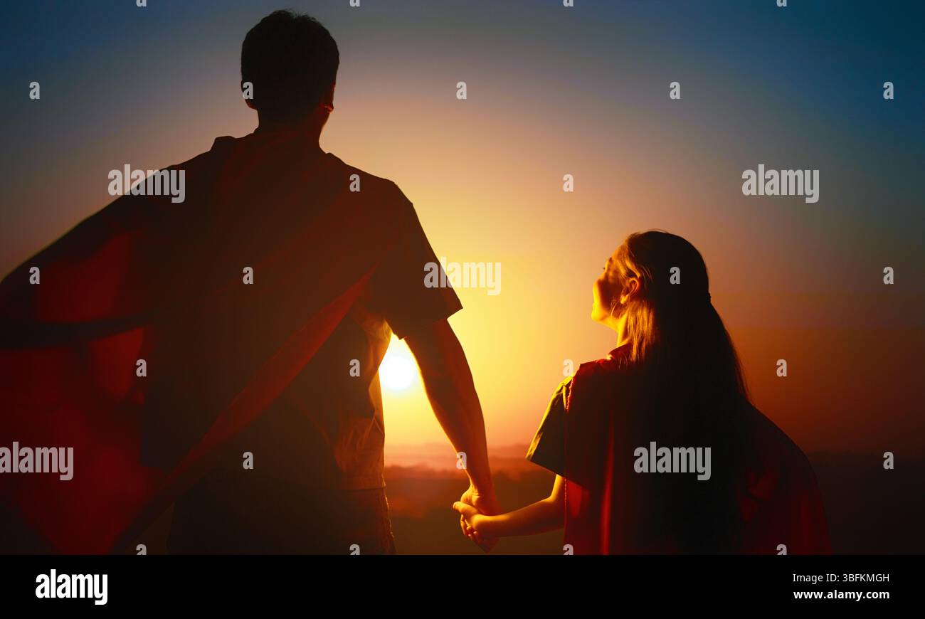 Famiglia felice amorevole. Padre e sua figlia giocano all'aperto. Daddy e la sua bambina in costumi di un Supereroe. Foto Stock