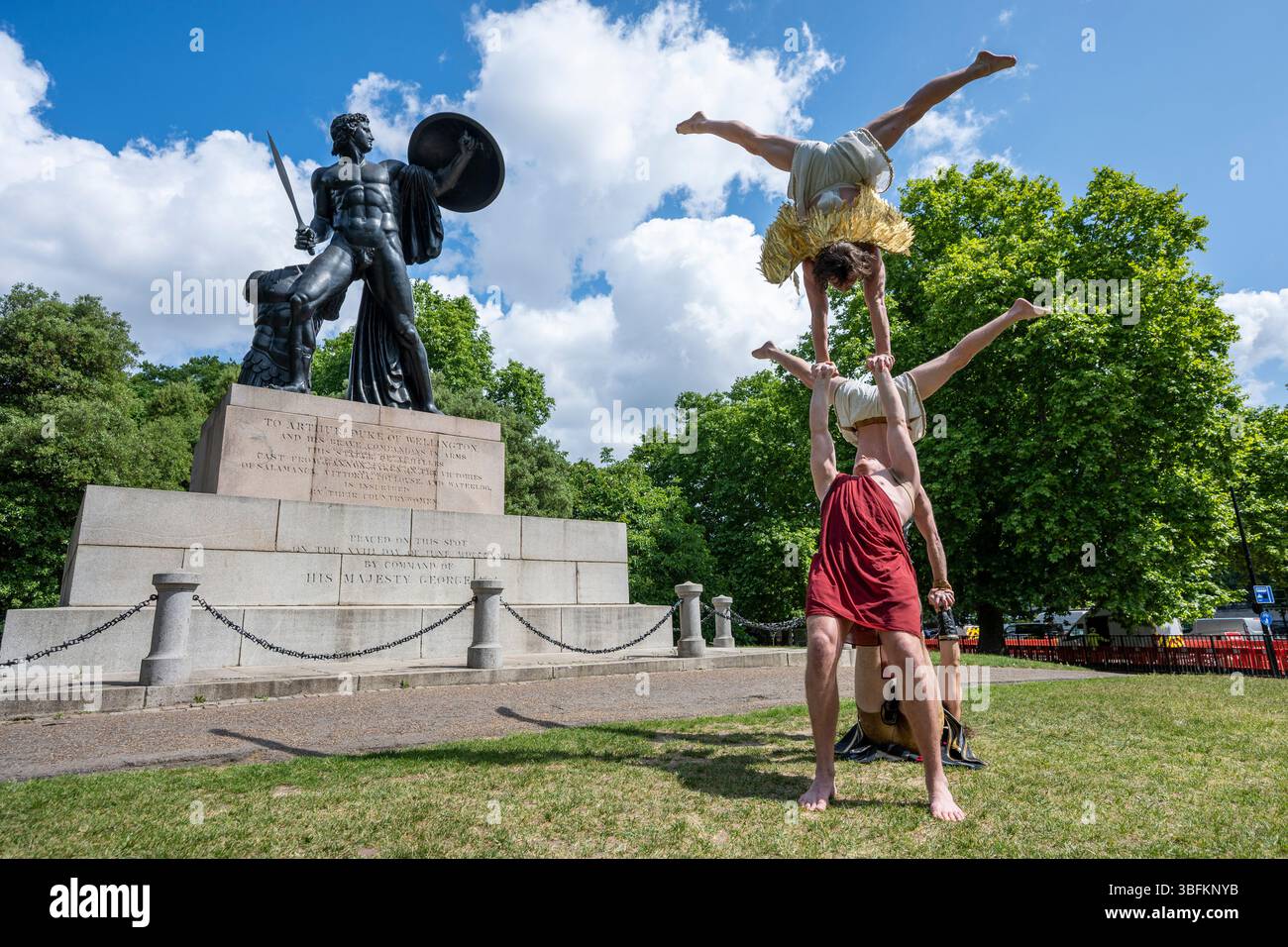 Londra, Regno Unito. 2 giugno 2025. La troupe acrobatica australiana, Head First Acrobats, si esibisce di fronte alla classica statua greca di Achille a Hyde Park mentre lanciano il loro spettacolo a tema mitologico greco GODZ, che può essere visto al Peacock Theatre dall'11 al 14 giugno. Crediti: Stephen Chung / Alamy Live News Foto Stock