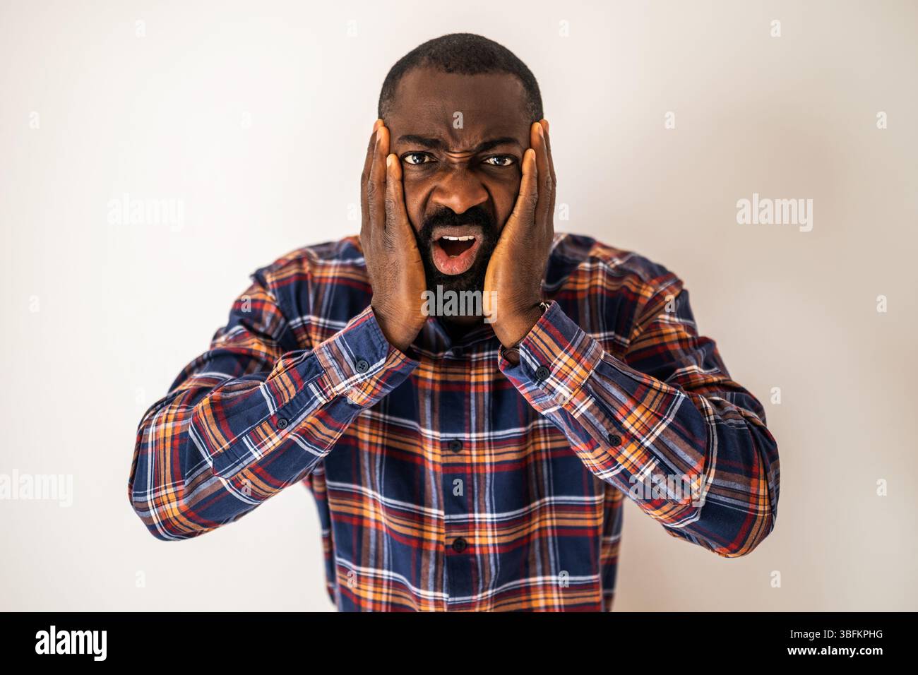 Ritratto di un uomo nero emotivamente stressato, confuso e scioccato che guarda la fotocamera. Foto Stock