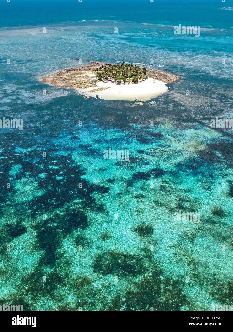Spettacolare vista aerea della vibrante barriera corallina, delle acque turchesi e di una barra di sabbia bianca al largo della remota isola di Guyam a Siargao, Filippine. A. Foto Stock
