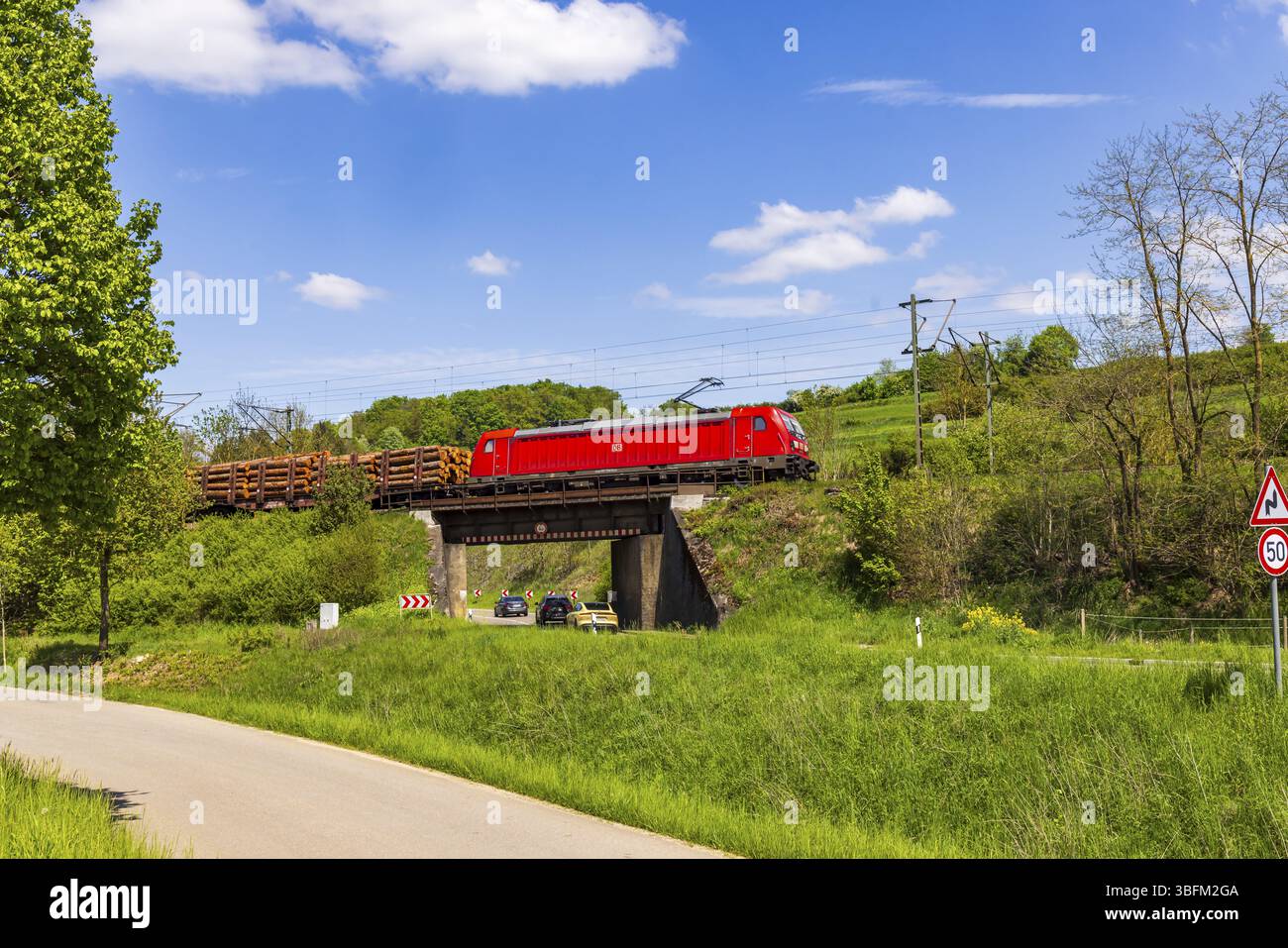 Treno merci che viaggia sull'Alb svevo vicino a Lonsee. Paesaggio lungo la linea ferroviaria in primavera. Lonsee, Baden-Wuerttemberg, Germania, Europa Foto Stock