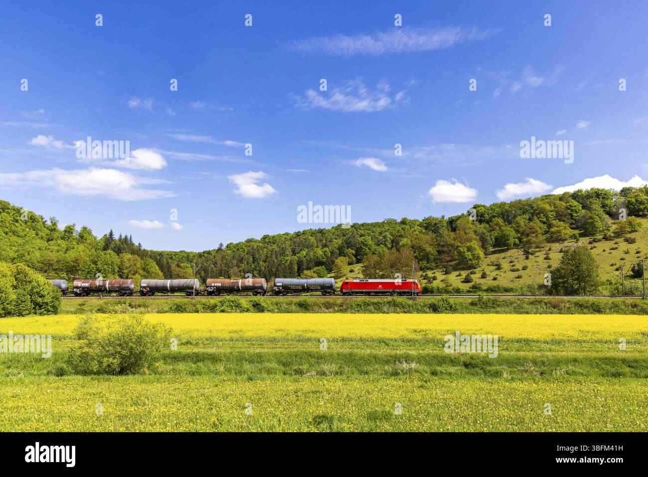 Treno merci che viaggia sull'Alb svevo vicino a Lonsee. Paesaggio lungo la linea ferroviaria in primavera. Lonsee, Baden-Wuerttemberg, Germania, Europa Foto Stock