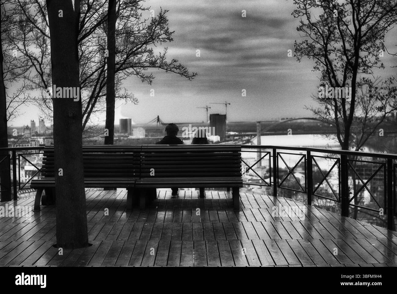 Passerella in legno all'aperto con panchine. Area salotto all'aperto con sfondo lago. Foto Stock