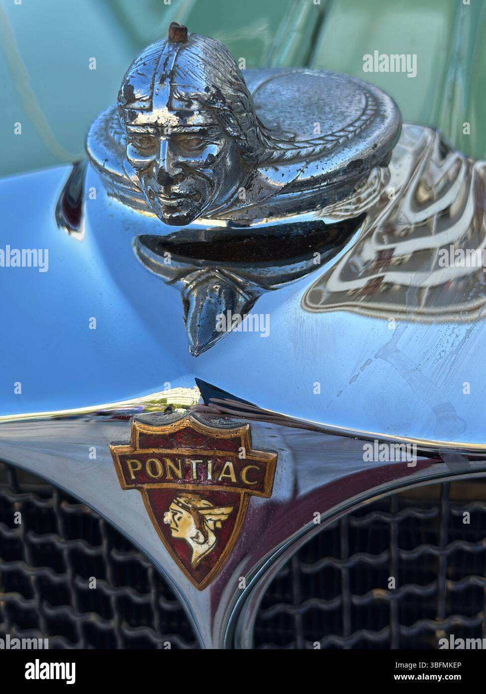 Albufeira, Portogallo - 24 maggio 2025: L'ornamento del cofano del tappo del radiatore Pontiac d'epoca viene mostrato da vicino su un'auto in una vista ravvicinata durante il giorno. Foto Stock