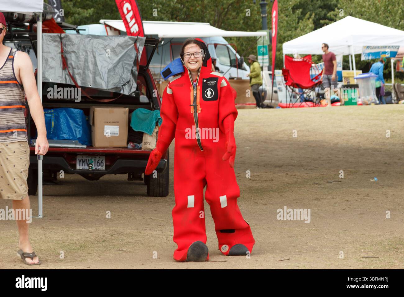 The Big Float, Portland, Oregon - 10 luglio 2016: Una donna con una muta rossa sorride, pronta a galleggiare lungo il fiume Willamette con altri. Foto Stock