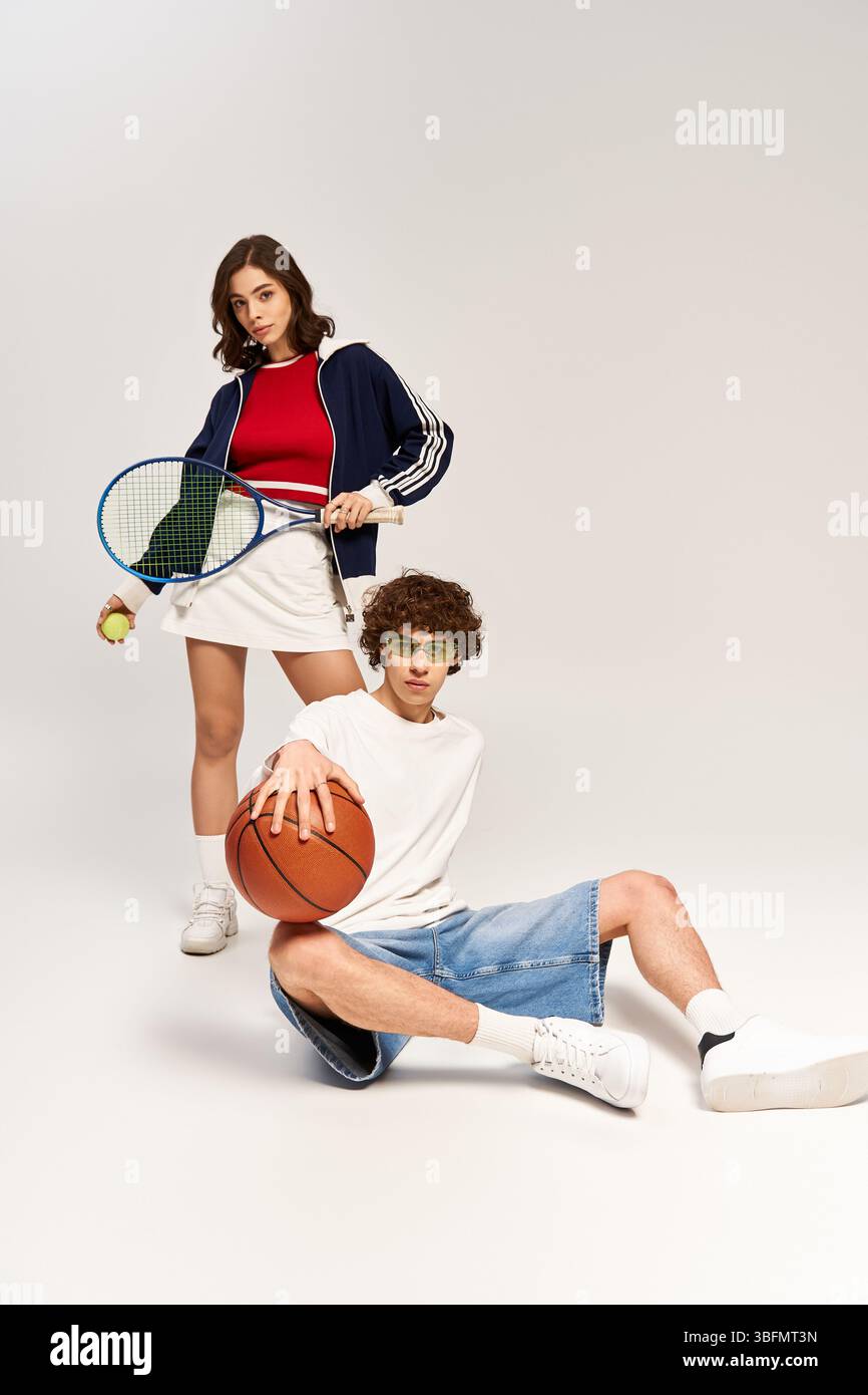 La giovane coppia esprime la propria passione per il tennis e il basket, irradiando amore e stile. Foto Stock