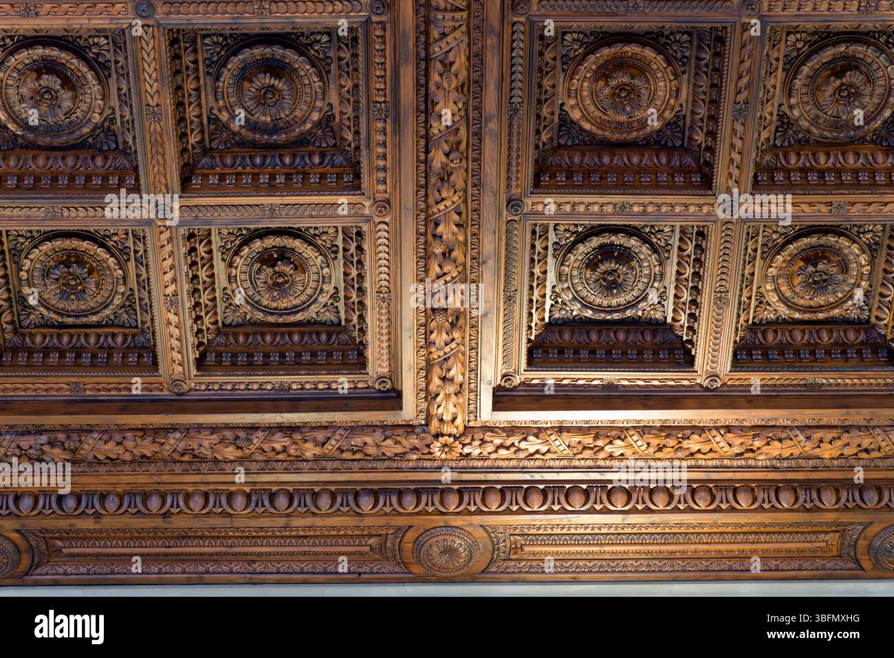 Soffitto decorato in legno a cassettoni con rosoni scolpiti e motivi classici a Palazzo Pitti, Firenze, Italia, che mostra l'artigianato rinascimentale. Foto Stock
