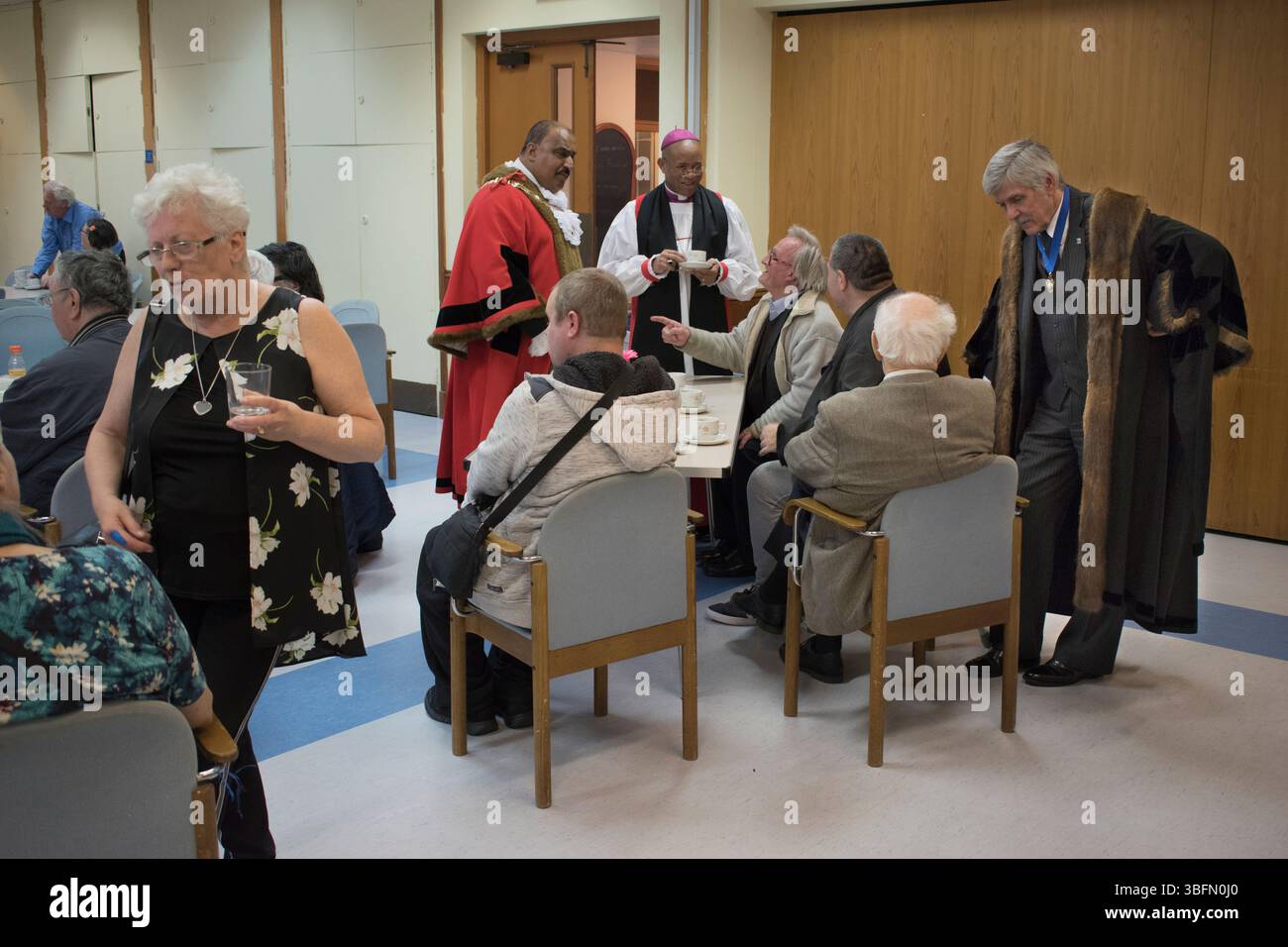 Nepton Distribution at St Margaret's Church, Barking, Essex. È la carità monetaria più longeva del paese dopo il Maundy Money. La distribuzione si svolge nel Centro della Chiesa, alla quale partecipano il Sindaco di Barking, il rettore di Santa Margherita e vari dignitari della compagnia di Poulters che amministrano l'ente caritatevole. Sindaco di Barking Consigliere Abdul Aziz, Rt Revd Trevor Mwamba, Reg Beer JP, alto direttore della Worshipful Company of Poulters. Tè e biscotti con i beneficiari dopo la distribuzione. Inghilterra 21 maggio 2019 2010s Regno Unito HOMER SYKES Foto Stock