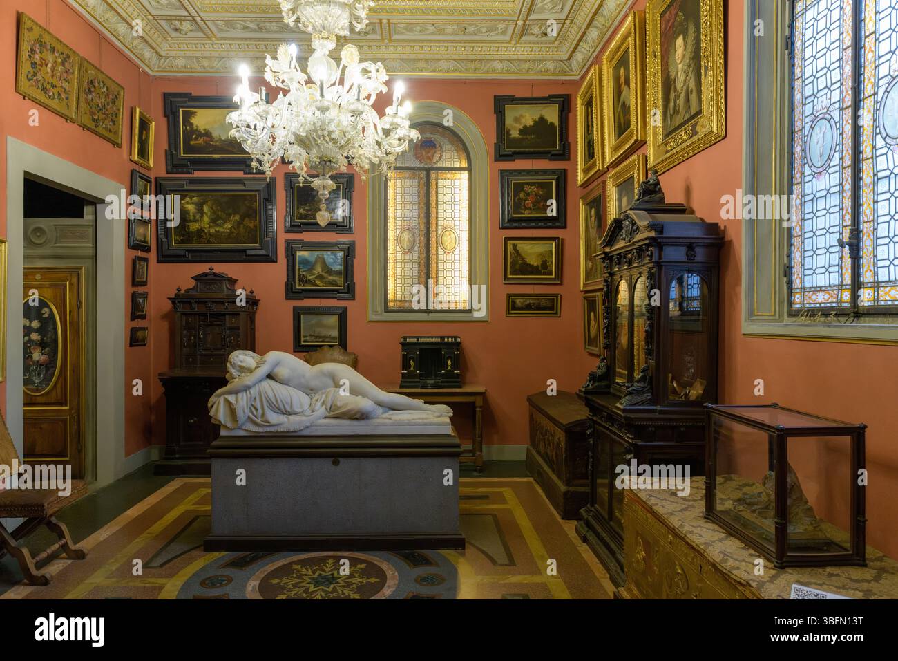 Interno del Museo Stibbert di Firenze, in Italia, che mostra una sala con mobili del XIX secolo, dipinti e uno scultore funerario in marmo neoclassico Foto Stock