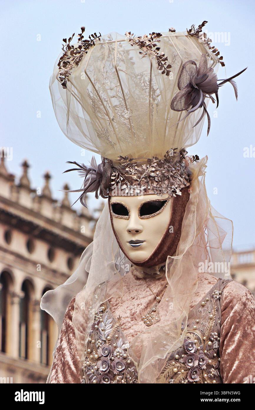 Maschera veneziana, ornata e misteriosa, risplende con accenti d'oro, piume e motivi intricati, evocando la grandiosità dei carnevali del vecchio mondo a Venezia. Foto Stock