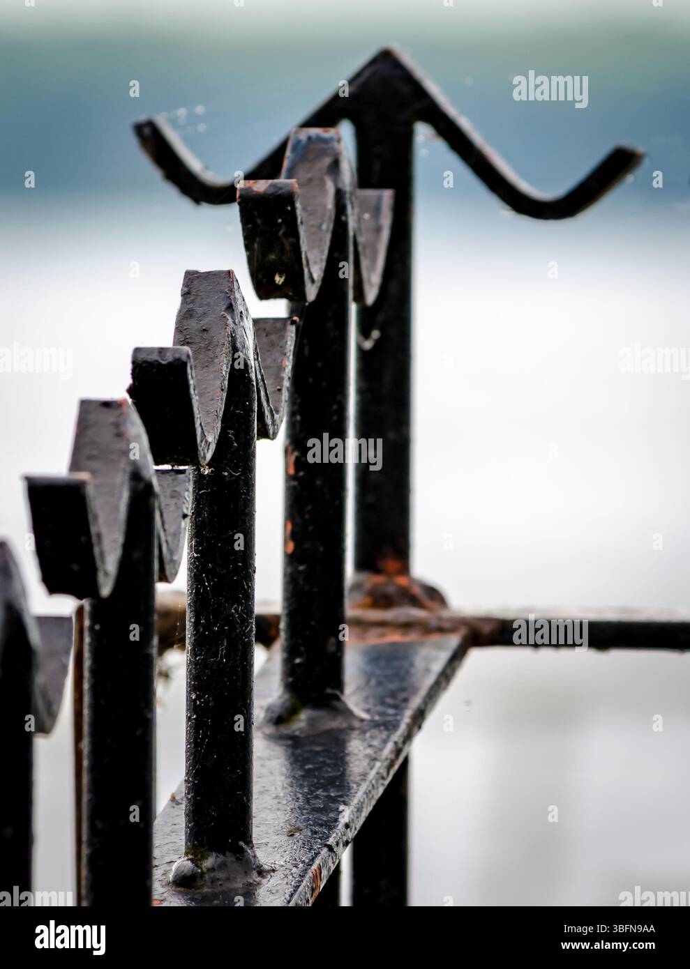 Primo piano di recinzione metallica con finiture di base con sfondo sfocato. Foto Stock