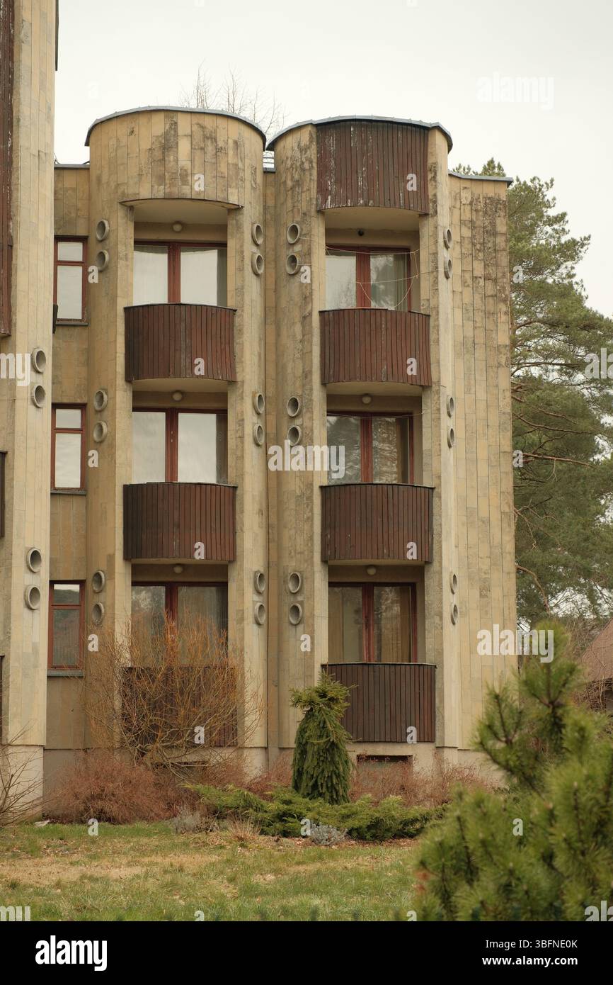 Facciata di un appartamento di epoca sovietica o di un edificio sanatorio con distinti elementi di ventilazione circolare e balconi di legno scuro. Foto Stock