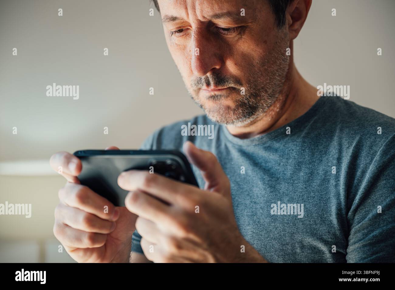 Videogamer che gioca a videogame di intrattenimento su telefono cellulare, con messa a fuoco selettiva Foto Stock