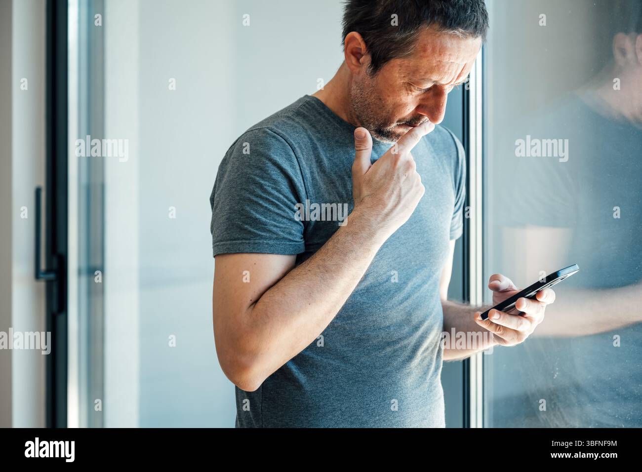 Lettura di messaggi di testo preoccupanti sul telefono cellulare, messa a fuoco selettiva Foto Stock