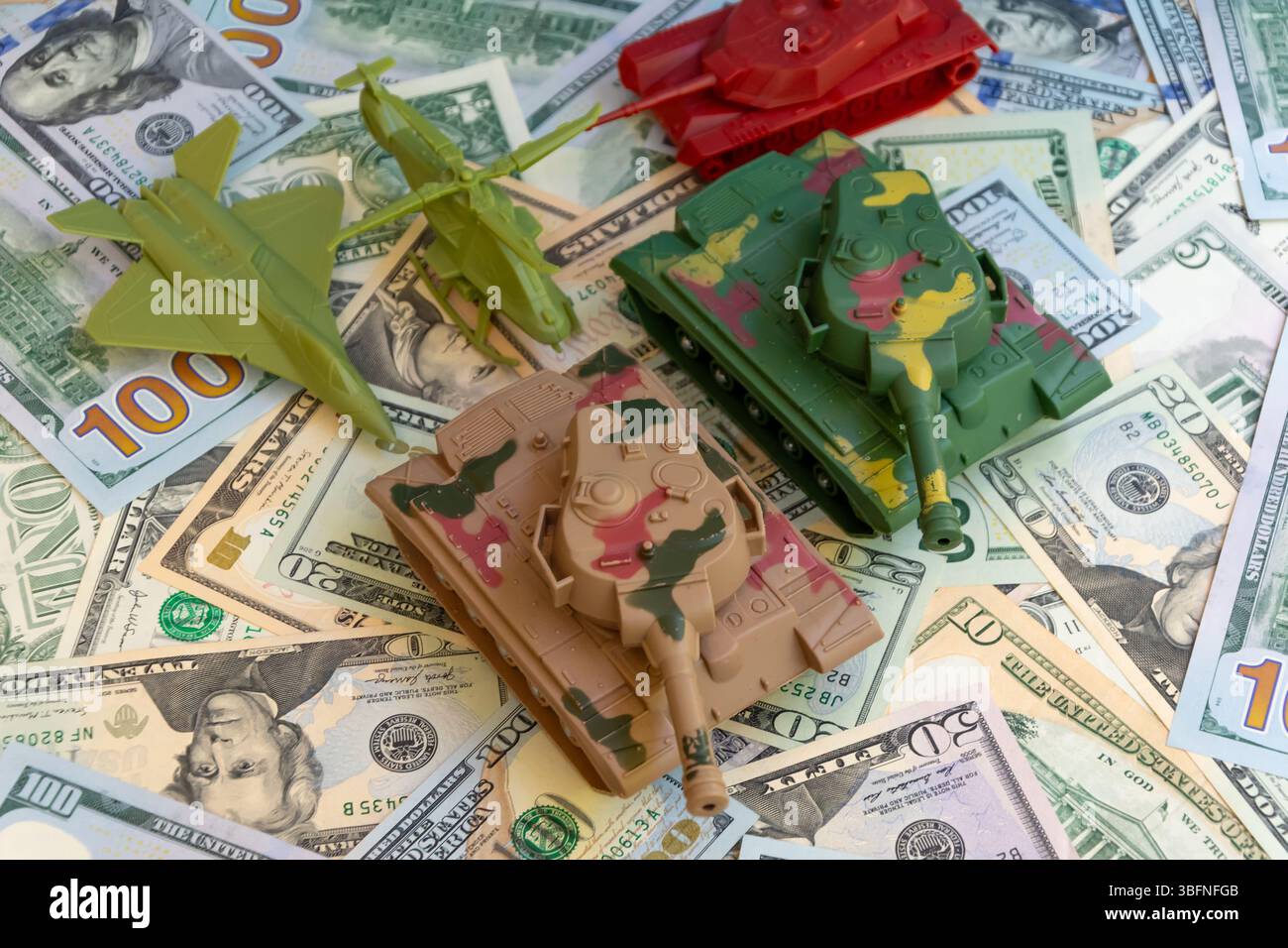 Finanziare la spesa militare degli Stati Uniti. Carri armati giocattolo, aereo ed elicottero sullo sfondo di dollari americani. Concetto di bilancio per la difesa, militarizzazione A. Foto Stock