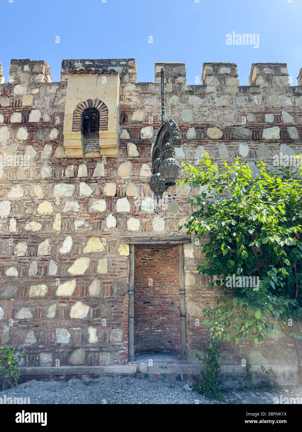 Frammento di mura medievali della fortezza con nicchia, struttura in pietra e mattoni, finestra ad arco e lanterna. Tbilisi, Georgia. Niente persone. Foto Stock