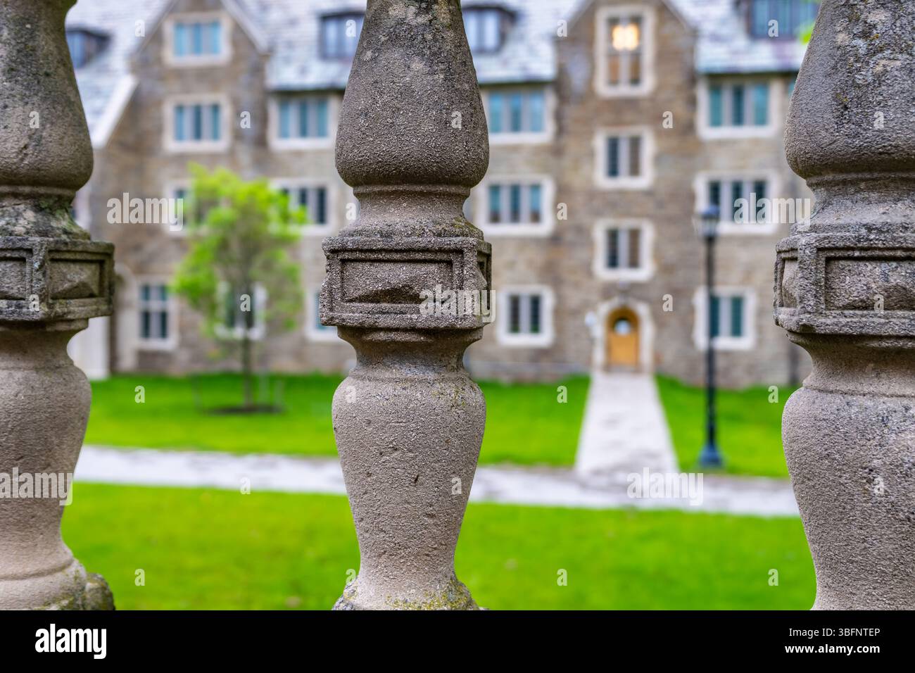 Esterno di un dormitorio gotico collegiale, con la porta esterna incorniciata tra pilastri in cemento fuso. Foto Stock