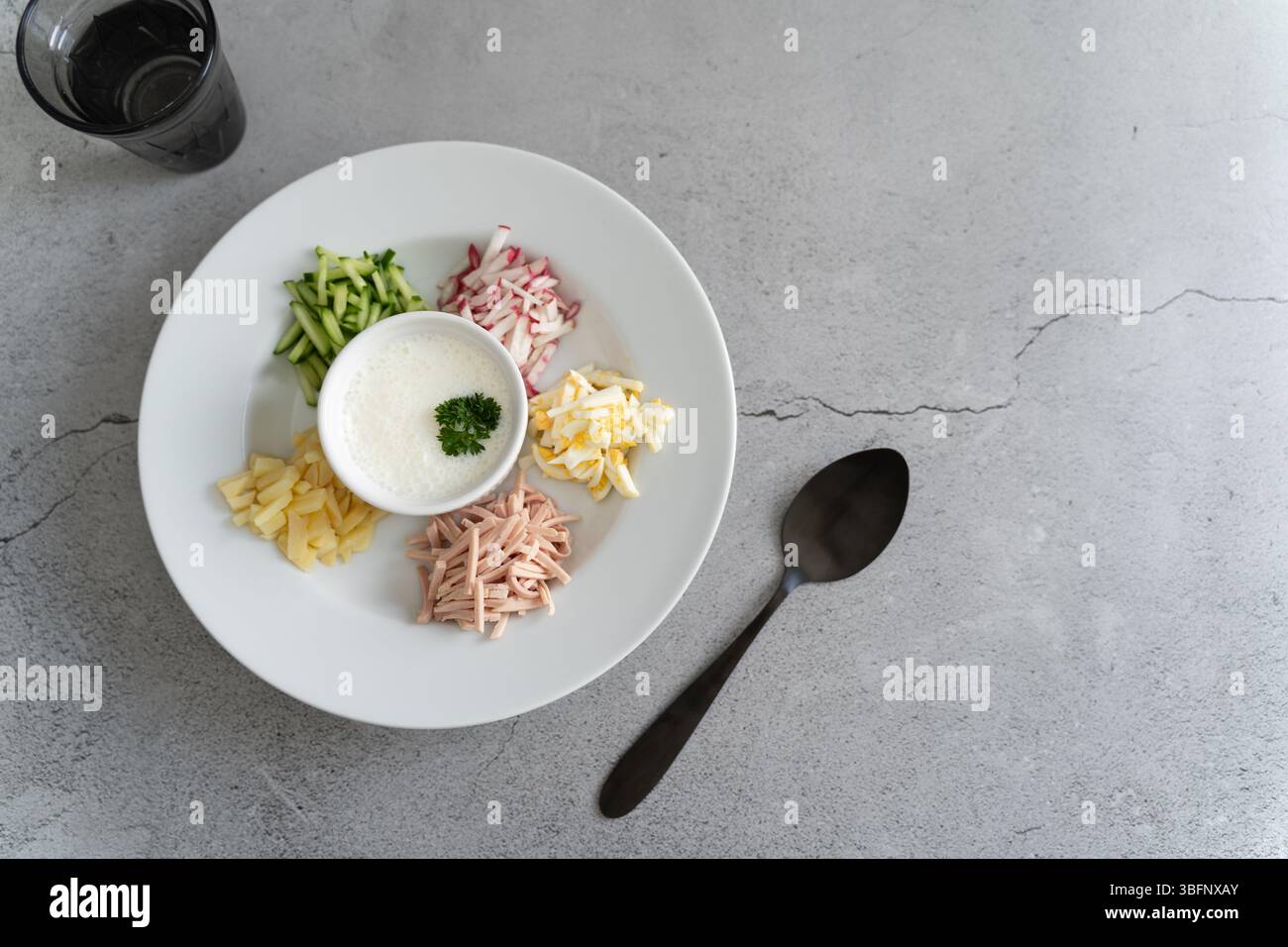 Un mix vibrante di cetrioli freschi, ravanelli, uova sode, prosciutto, panna acida, aneto, prezzemolo, incarna splendidamente l'essenza di Okroshka, un rinfrescante Ru Foto Stock