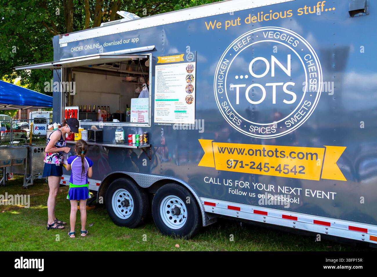 The Big Float, Portland, Oregon - 13 luglio 2019: Un ordine donna e bambino dal food truck On Tots in occasione di un evento all'aperto. Foto Stock