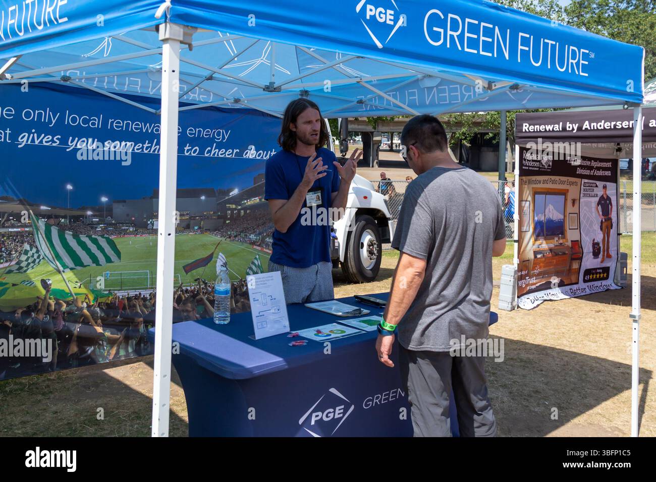 The Big Float, Portland, Oregon - 13 luglio 2019: Un rappresentante PGE spiega i vantaggi dell'energia verde a un potenziale cliente. Foto Stock