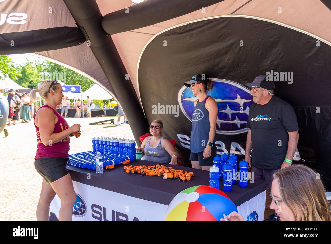 The Big Float, Portland, Oregon - 13 luglio 2019: Gli ambasciatori Subaru regalano bottiglie d'acqua e piccole imbarcazioni gonfiabili presso uno stand. Foto Stock
