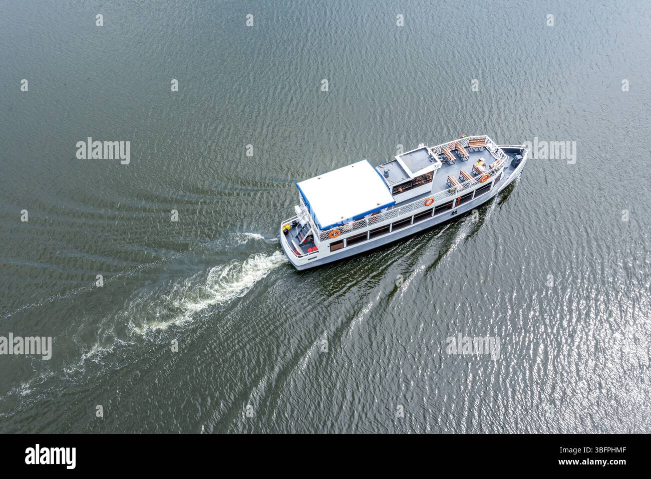 barca da crociera che si muove rapidamente sul fiume con una traccia bianca alle spalle. vista aerea. Foto Stock