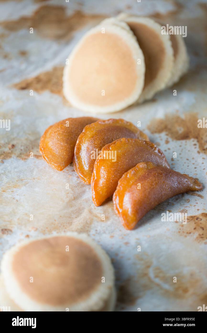 Croccanti Qatayef, frittelle arabe fritte ripiene di noci e condite con sciroppo Foto Stock