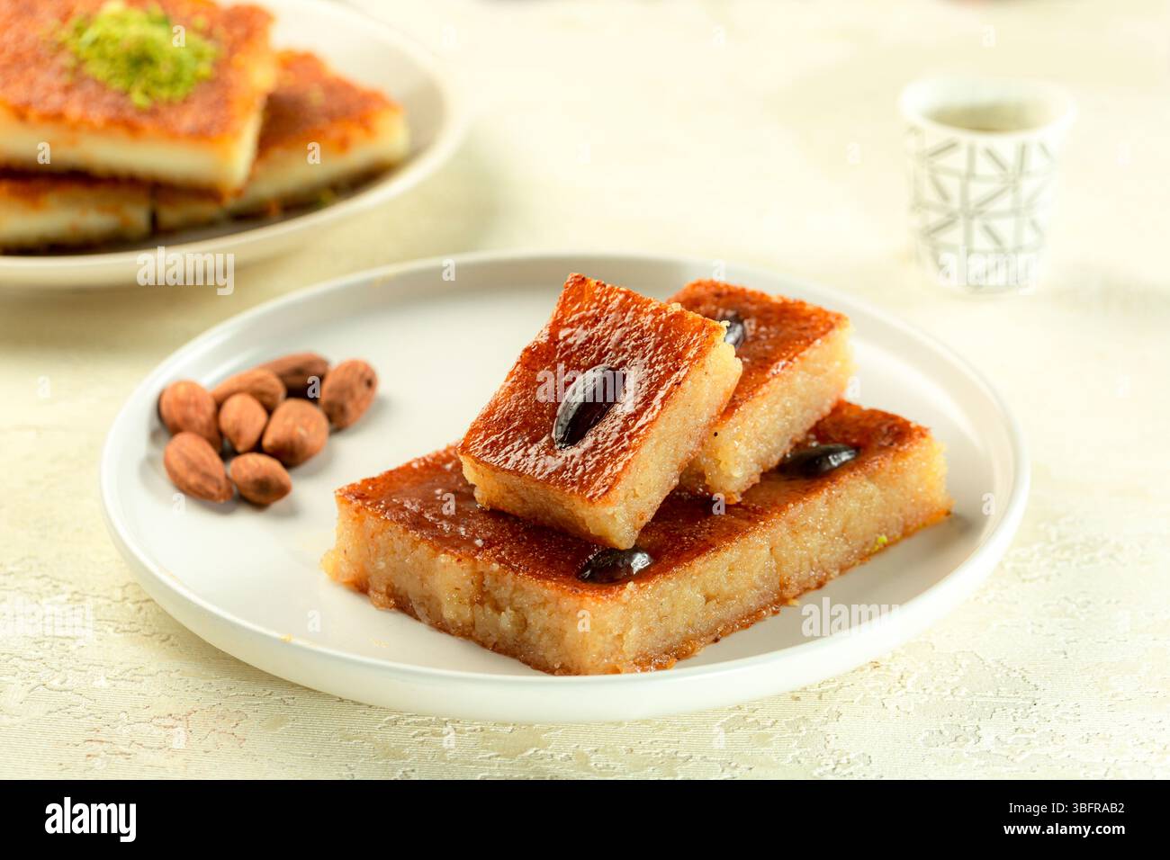 Classico dessert Namoura mediorientale a base di ghee e noci, servito su sfondo bianco Foto Stock