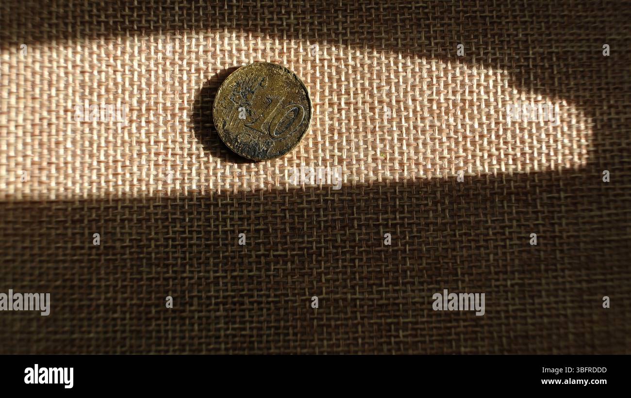 Moneta Eurocent da 10 su tessuto rustico alla luce del sole – primo piano macro Foto Stock