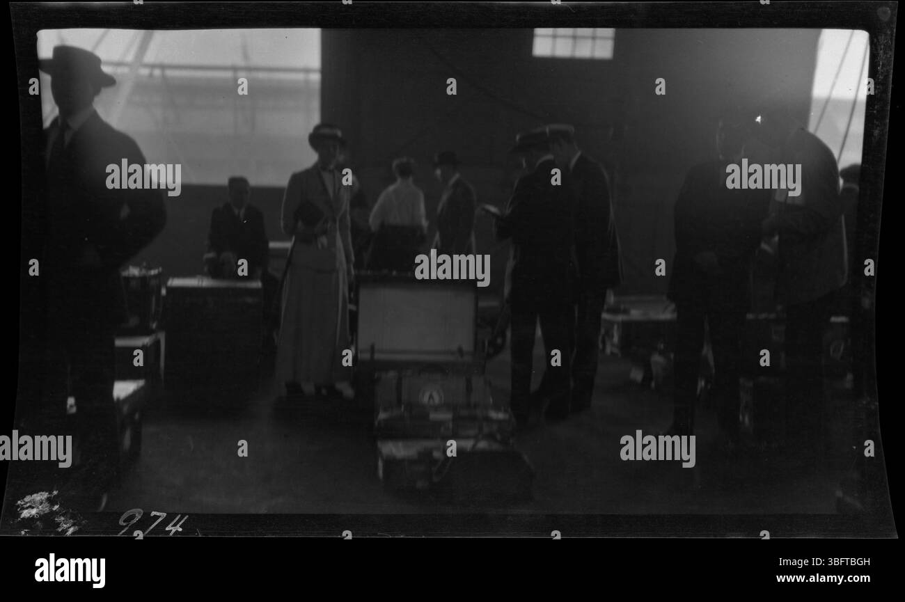 Elizabeth Arras si trova accanto ai suoi bagagli durante un'ispezione dei bagagli al porto di New York nel 1913. Questa fotografia faceva parte di una raccolta di immagini scattate dalla famiglia Arras durante il loro ritorno dall'Europa, documentando i loro viaggi e il processo doganale. Foto Stock