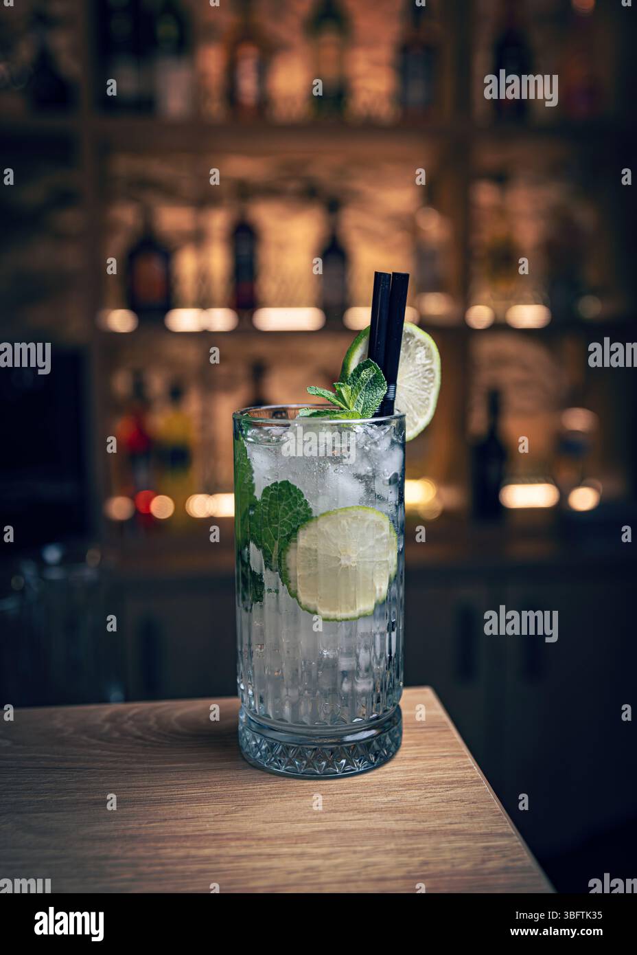 Rinfrescante cocktail di mojito seduto sul bancone del bar con bar sul retro sfocato sullo sfondo Foto Stock Rinfrescante cocktail di mojito seduto sul bancone del bar con bar sul retro sfocato sullo sfondo Foto Stock