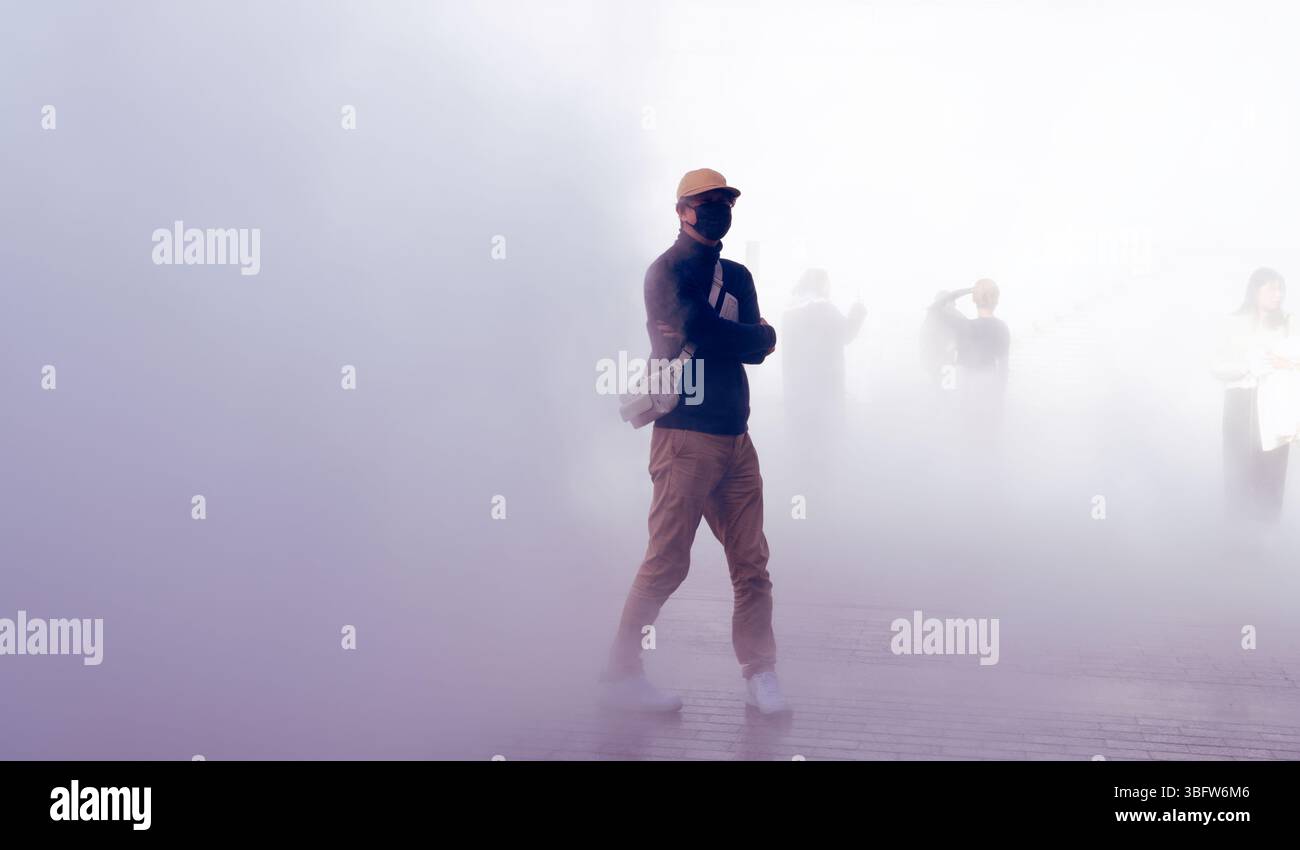 Il visitatore fa una pausa all'interno dell'installazione immersiva della nebbia di SEE Sound, Hearing Time di Ryuichi Sakamoto Foto Stock