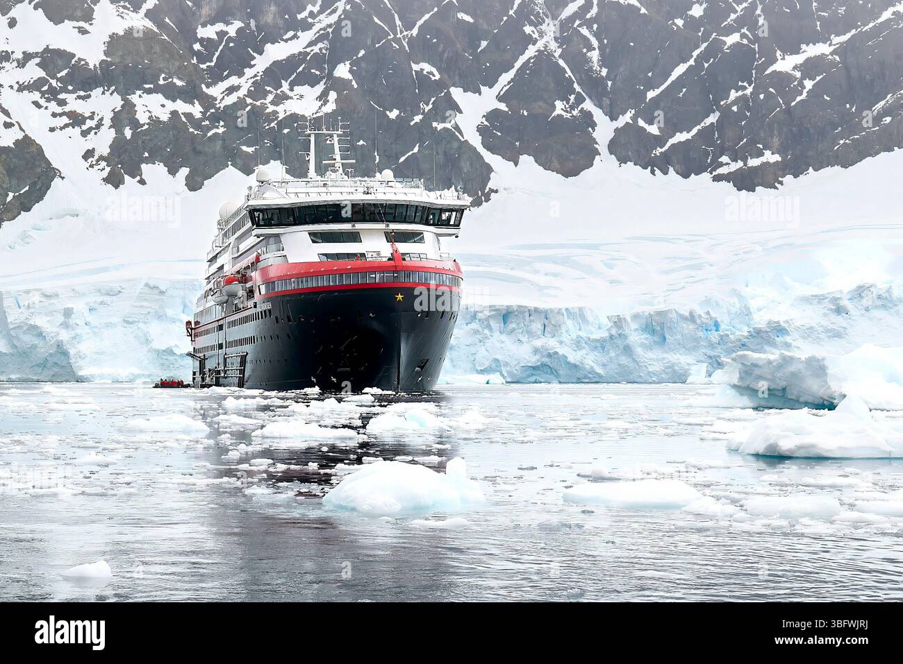 La nave da crociera ibrida Hurtigruten Expeditions MS Roald Amundsen nel porto di Niko nella baia di Andvord sulla costa occidentale della Terra di Graham, in Antartide Foto Stock