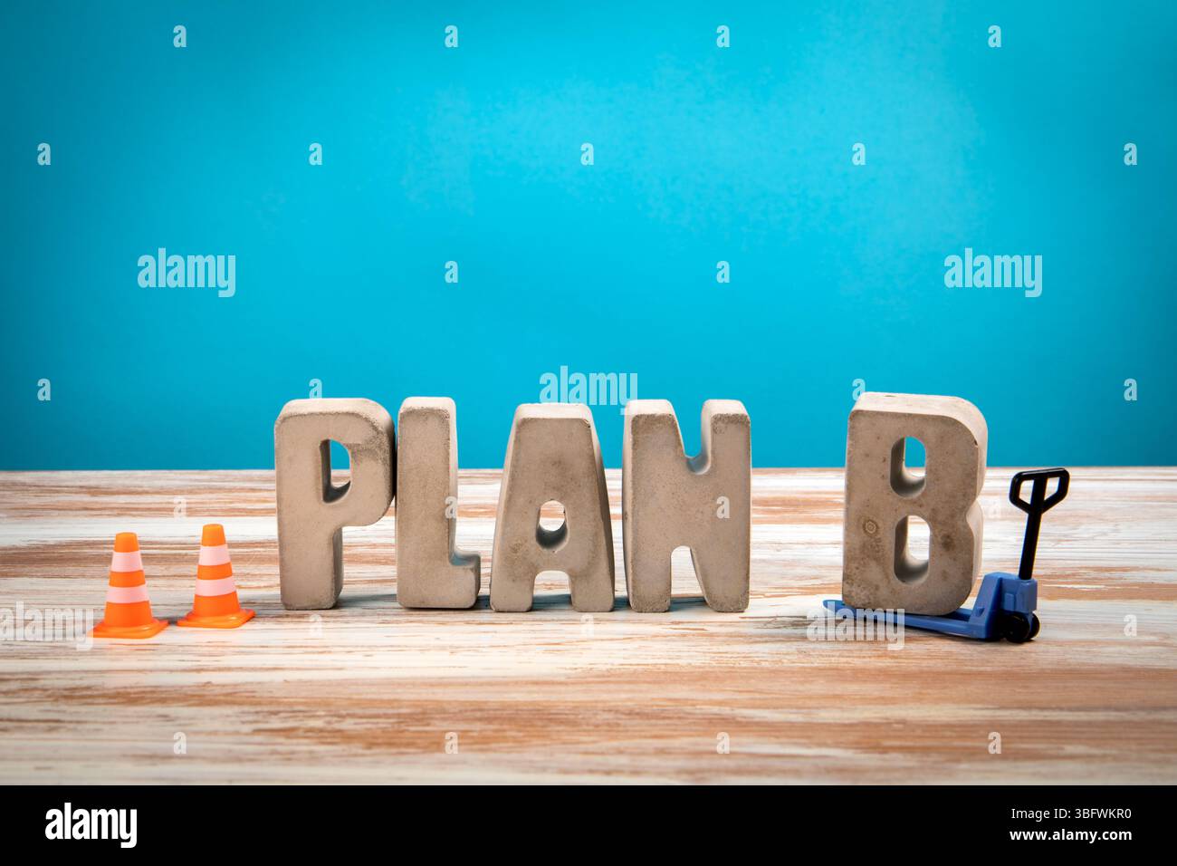 Plan B. lettere alfabetiche in cemento su sfondo bianco in legno e blu. Foto Stock