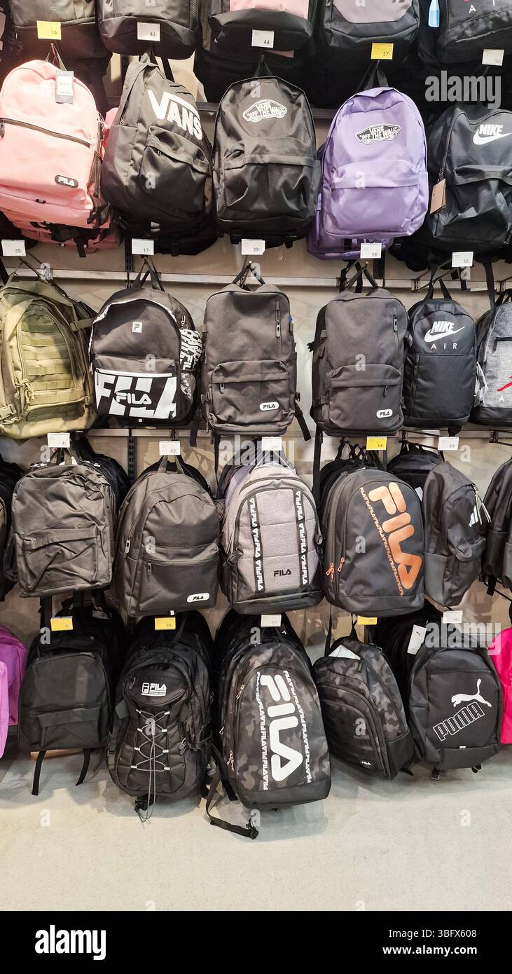 Almeria, Spagna - 02 giugno 2025: Esposizione di zaini neri alla moda di marchi come fila e Puma su una parete di vendita al dettaglio, perfetti per studenti e fashion lo Foto Stock