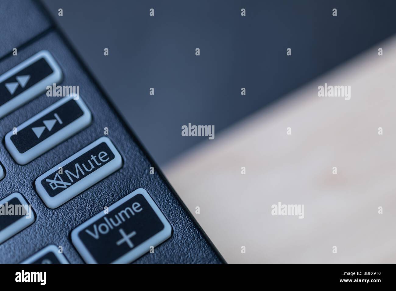 Primo piano del telecomando che mostra i pulsanti di volume, esclusione microfono e inoltro, concetto tecnico astratto per il controllo e l'interfaccia multimediale Foto Stock