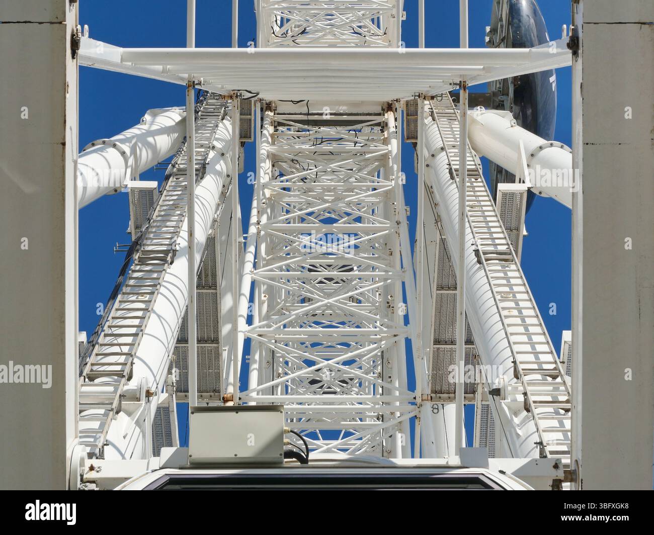 Grande ruota panoramica bianca con gondole chiuse contro il cielo limpido. Geometria accattivante, soggetto resistente per gli appassionati di design e ingegneria. Copia spazio. Foto Stock