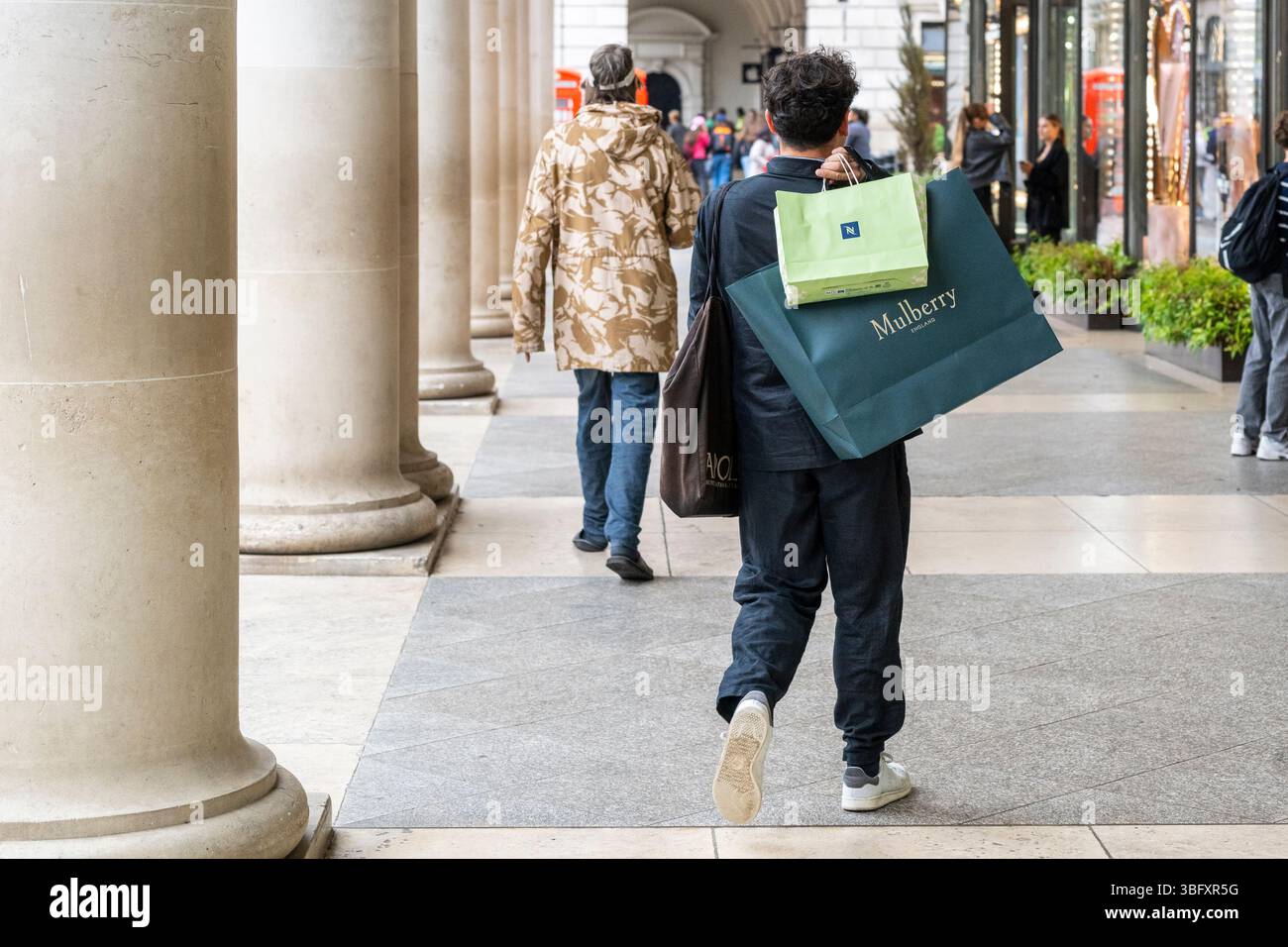 Londra, Regno Unito. 3 giugno 2025. Un acquirente con acquisti presso il negozio Mulberry di Covent Garden. L’Organizzazione per la cooperazione e lo sviluppo economico (OCSE) ha affermato che la crescita economica del Regno Unito sarà più lenta del previsto quest’anno e il prossimo a causa dell’impatto della guerra tariffaria di Donald Trump sul commercio e sugli investimenti, nonché di un’inflazione superiore al previsto. Si prevede che la crescita del Regno Unito scenderà dal 1,4% al 1,3% nel 2025 e dal 1,2% all'1% il prossimo anno. Crediti: Stephen Chung / Alamy Live News Foto Stock