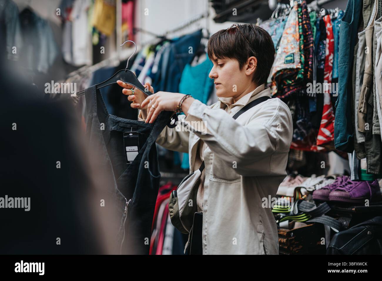 I giovani acquistano vestiti in un vivace negozio di seconda mano Foto Stock