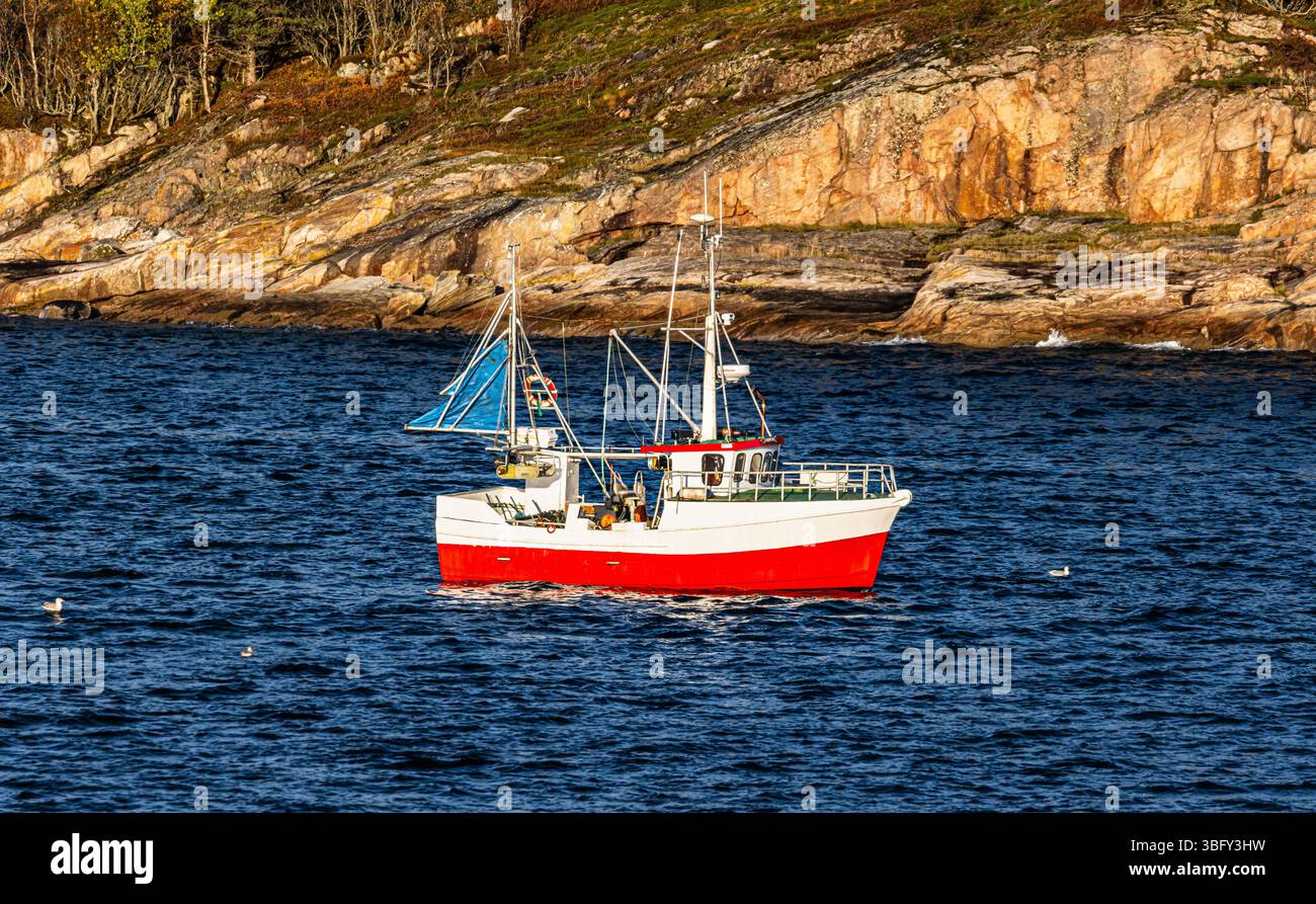 Ein kleines Fischerboot ist in den Morgenstunden unterwegs auf dem norwegischen Meer(Küstengebiet Norwegen, Region Nordland, 13.10.2023) Foto Stock