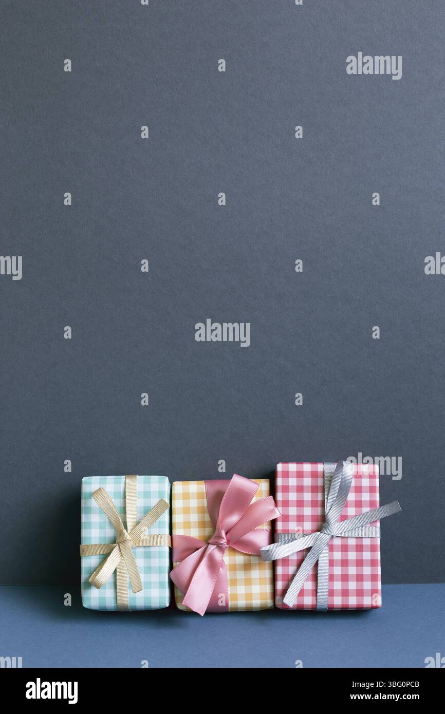 Scatole regalo colorate sul tavolo. sfondo blu navy parete Foto Stock