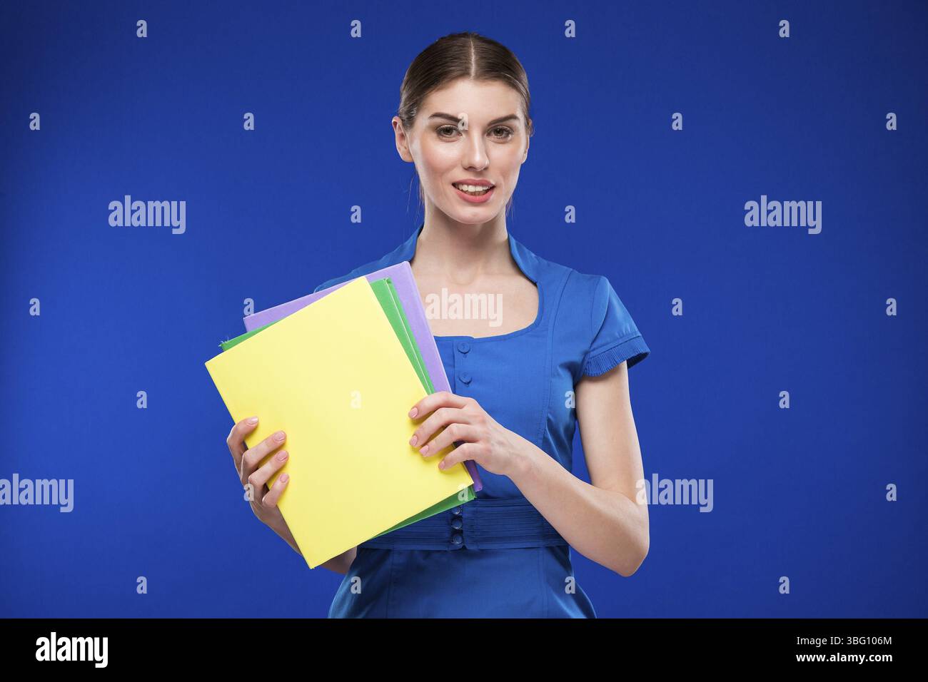 Ragazza con libri in mano su sfondo blu Foto Stock