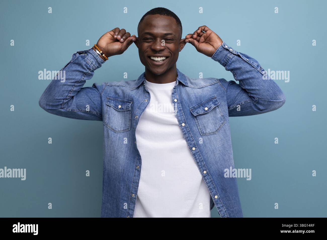 Bello, confuso, giovane e attraente uomo africano vestito casualmente in denim Foto Stock