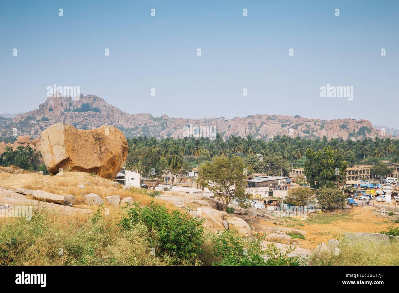 Montagne di pietra e palme, il paesaggio della città vecchia di Hampi, India, Asia Foto Stock