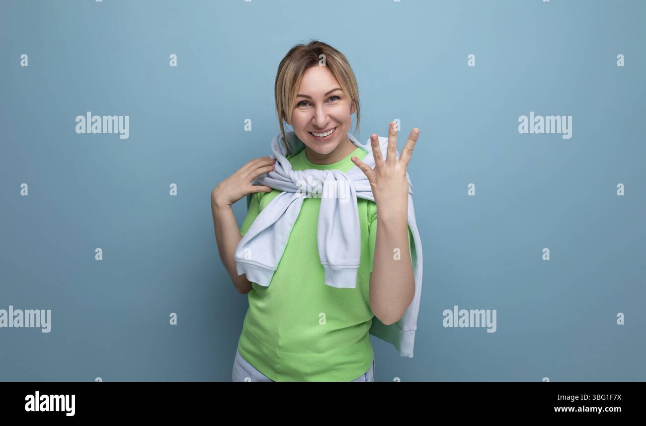 Foto orizzontale di una ragazza bionda brillante in un abito casual su sfondo blu con spazio per le copie Foto Stock