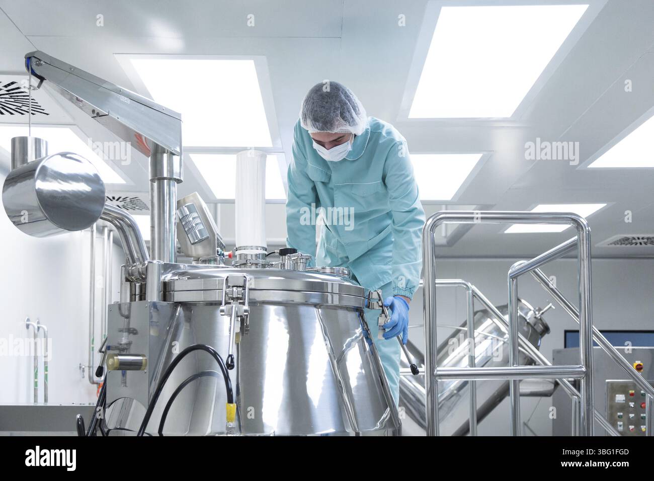 Fabbrica farmaceutica uomo lavoratore in abbigliamento protettivo il funzionamento della linea di produzione sterili in condizioni di lavoro Foto Stock