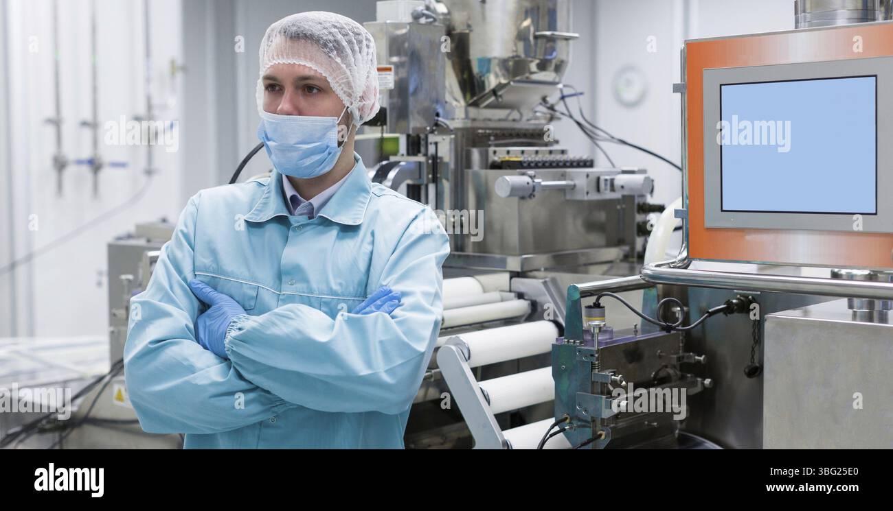 Widescreen, immagine di scienziato con mani incrociate in tuta da laboratorio in piedi vicino a una macchina in acciaio con alberi Foto Stock