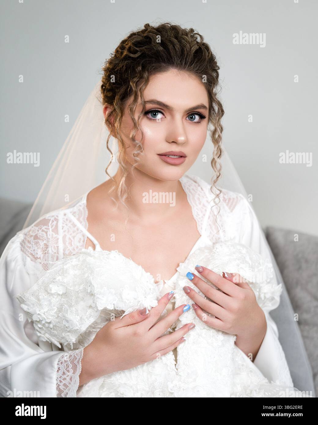 Ivano-Frankivsk, Ucraina, 22 settembre 2024: Una splendida sposa in un delicato abito in pizzo, che mostra i suoi bellissimi capelli ricci e il suo delicato trucco. L'immagine Foto Stock